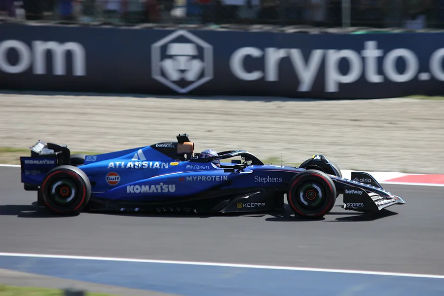 Alexander Albon’s Williams on track at Monza in 2025, under hard overhead sun with its shadow directly beneath it